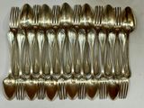 a lot of silver spoons and forks on a table