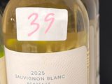plusieurs bouteilles de vin posées sur une étagère à côté d'une bouteille de vin