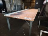 a wooden table with a metal frame in the middle of a room