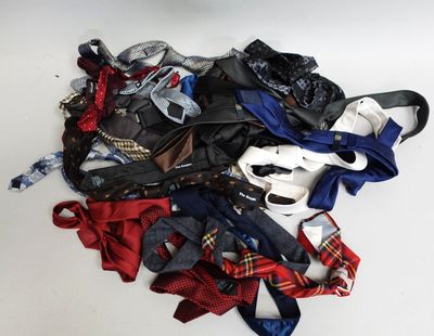 un tas de vêtements et de cravates posés sur une surface blanche