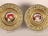 two gold plate with a picture of a man and a woman on them