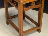 a small wooden table with carvings on the top
