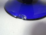 a blue glass vase sitting on a white table