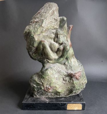 statue of a woman on a rock with a bird on her back