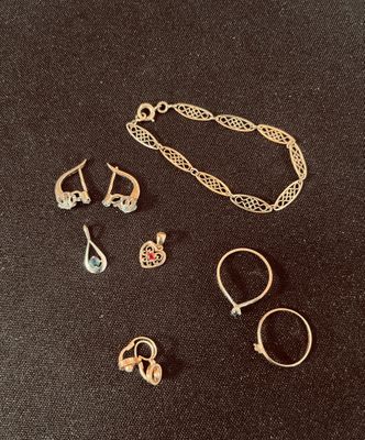 trois paires de bijoux en or et en argent sur un fond noir