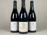 trois bouteilles de vin rouge posées sur une table