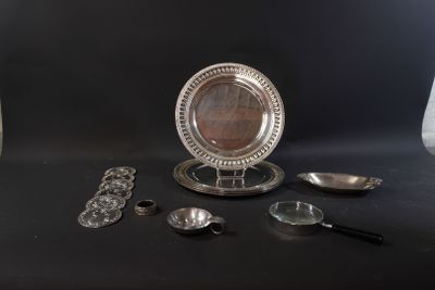 a silver plate with a mirror on it next to other silver objects