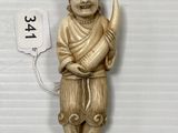 une statue en or représentant un homme tenant un poisson dans la main
