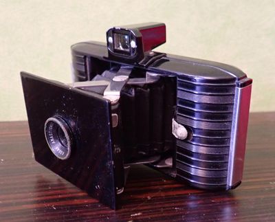 un petit appareil photo posé sur une table en bois