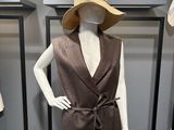 a mannequin wearing a brown dress and a hat on display