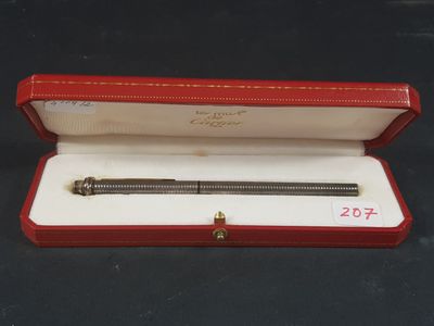 une image représentant un stylo dans un étui rouge posé sur une surface noire