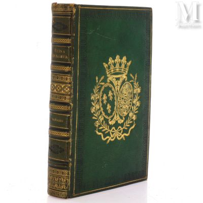 un vieux livre à la couverture verte posé sur une table blanche