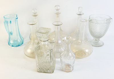 de nombreux vases en verre de différentes formes posés sur une surface blanche