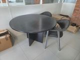 a black table and chairs in a room with a brick wall