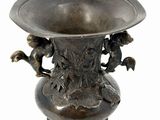 a bronze vase with birds on it on a white background