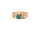 a close up of a gold ring with a green stone