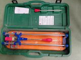 une mallette verte posée par terre, contenant des outils