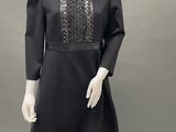 a mannequin wearing a black dress and white pants