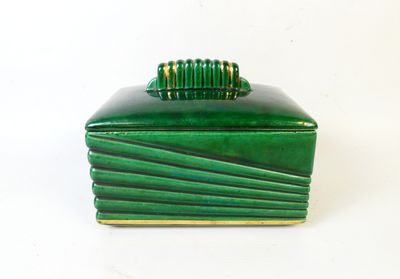 une boîte verte surmontée d'un anneau doré