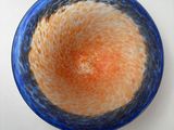a blue and orange bowl sitting on a white table
