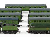 several green trains are lined up next to each other on a white surface