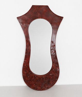 Miroir de forme mouvementée en métal à patine rouge nuancée,…