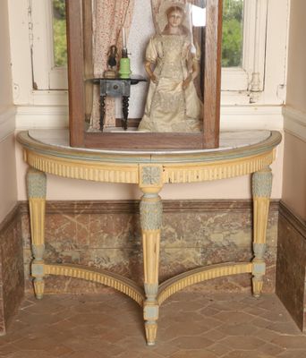 a statue of a woman sitting on a table in front of a mirror