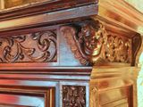 a close up of a wooden cabinet with a mirror in the background