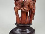 a statue of a man and a woman sitting on top of a vase