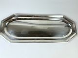 an image of a silver tray with a handle on a white table