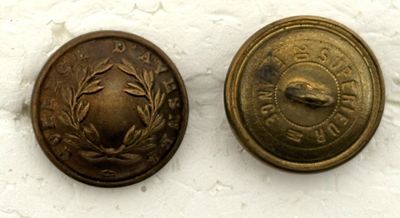 paire de boutons anciens en laiton ornés de feuilles de laurier sur un fond blanc