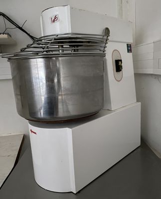 un grand saladier en métal posé sur une boîte blanche