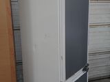 a refrigerator that is in a garage next to a wall