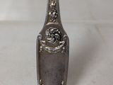 silver spoon with a rose on it sitting on a white surface