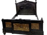 a black bed with gold decorations on the headboard