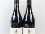deux bouteilles de vin posées l'une à côté de l'autre sur une surface blanche