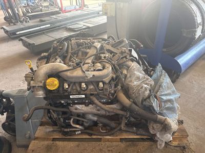 un moteur de camion posé sur une palette dans un garage