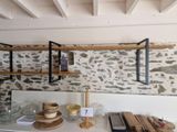 a kitchen with a stone wall and shelves on the wall