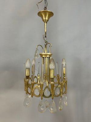 un lustre ancien en laiton orné de pendants en verre transparent suspendu au plafond