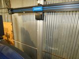 une image représentant un garage avec un mur métallique et une porte
