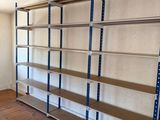 une pièce avec un parquet et des étagères métalliques