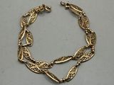 a gold bracelet on a white surface