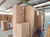 boxes are stacked on pallets in a warehouse with a metal roof
