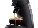 two cups of coffee being poured into a coffee machine