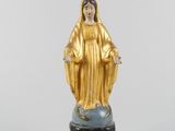 une image représentant une statue de la Vierge de Guadalupe posée sur un globe terrestre