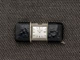 une petite montre posée sur un morceau de tissu