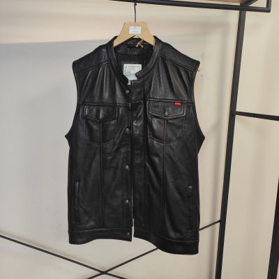 un gilet en cuir noir suspendu à un porte-manteau dans une pièce