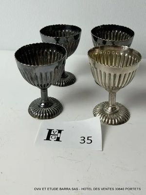 trois gobelets en argent posés sur une table, à côté d'une étiquette de prix