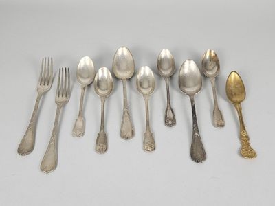 six spoons and a fork are lined up on a white surface