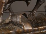 a bronze statue of a man on a horse with a barrel
